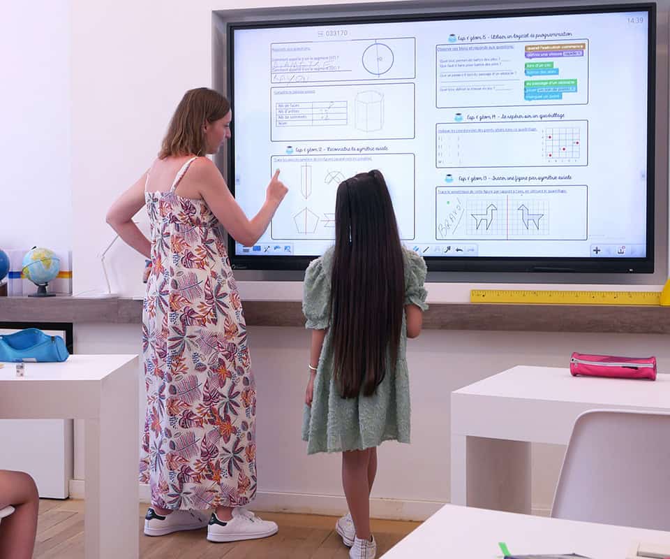 The teacher uses a touch screen to display graphics and images