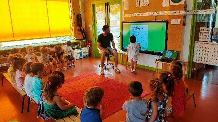 a kindergarten class in front of an interactive screen Photo : Primàbord