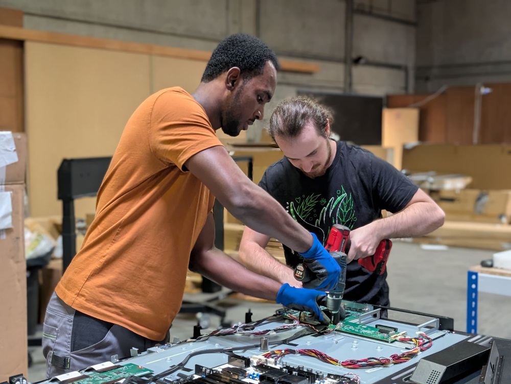 Grégoire und Abdel bei der Reparatur eines interaktiven Speechi-Bildschirms